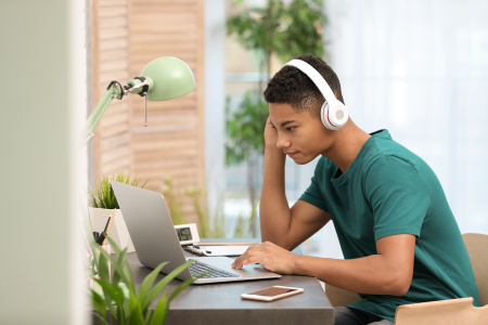 boy-studying-on-laptop-wearing-headphones