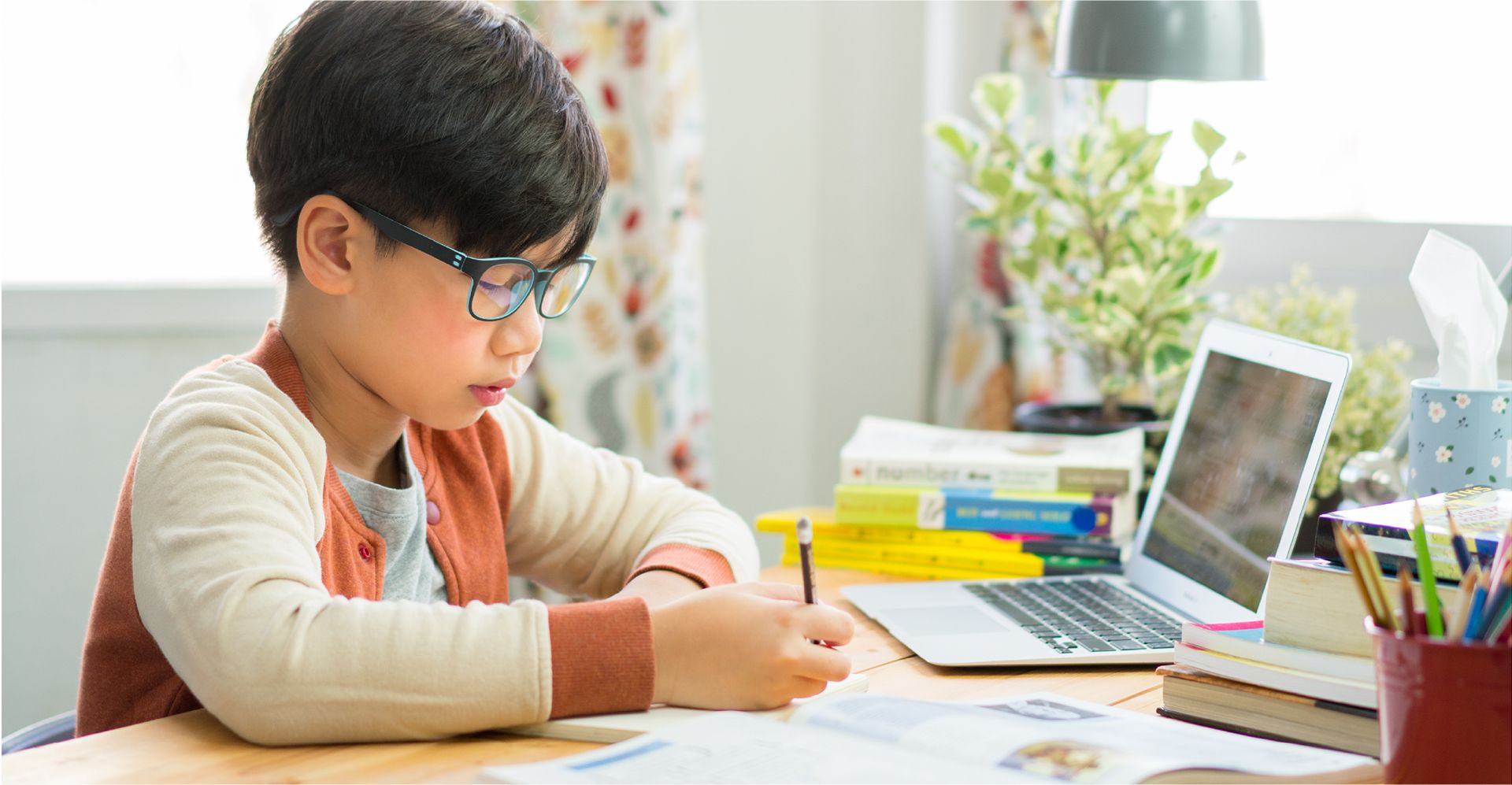 Young student siting at a laptop working on school work